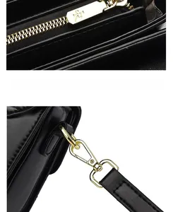 Detail of black leather bag with gold metal zipper and detachable shoulder strap hook