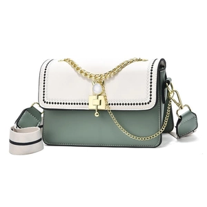 Chic two-tone crossbody bag with cat-ear pearl lock and woven edges on white background
