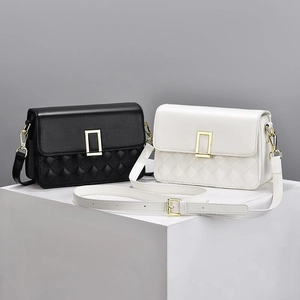 Classic quilted crossbody bag in black and white with elegant gold rectangular buckle
