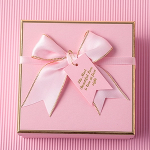 Pink square gift box with gold trim, satin bow and romantic quote tag detail