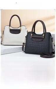 Detail of luxury crocodile texture handbags in black and white with metal hardware