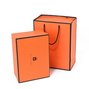 Premium orange gift box and matching paper bag set with black border accents and text