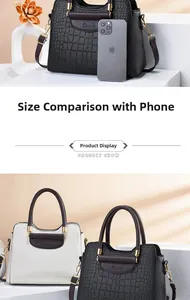 Detail of crocodile embossed handbag showing size comparison with smartphone and dual colors