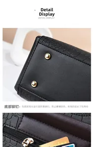 Detail of crocodile embossed leather handbag featuring gold metal rivets and card slots