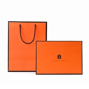 Elegant orange gift box and matching carrier bag with black border and woven handles