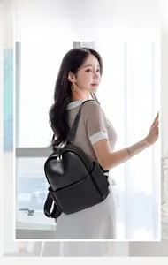 Detail of a chic black faux leather backpack with double zippers and side pockets