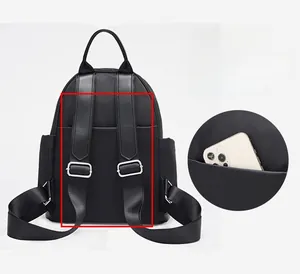 Detail of hidden anti-theft back pocket and reinforced straps on black backpack