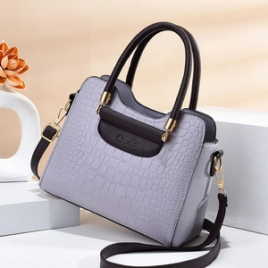 Lavender crocodile embossed handbag with contrasting dark brown handle and gold hardware