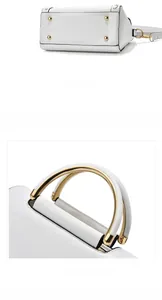Detailed view of white leather bag featuring gold protective studs and metallic ring handles