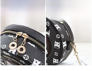 Detail of round black cat bag showing lychee grain leather and golden metal hardware