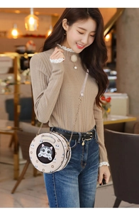 Detail of round crossbody bag with cute cat motif and elegant metal chain strap