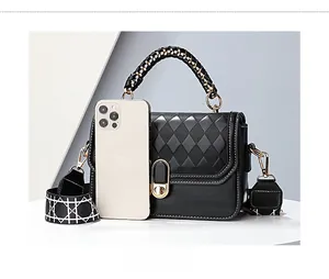 Close-up of black quilted leather handbag with chic woven handle and patterned strap