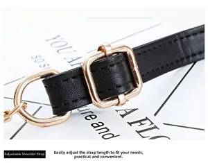 Detail of adjustable black faux leather shoulder strap with light gold metal buckle hardware