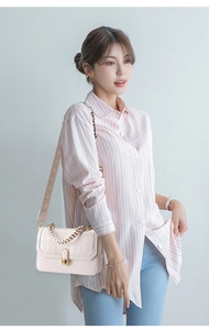 Quilted beige leather crossbody bag with gold hardware and wide woven strap on a model