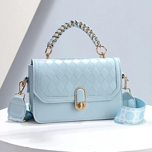 Elegant light blue quilted handbag with woven handle and patterned wide shoulder strap