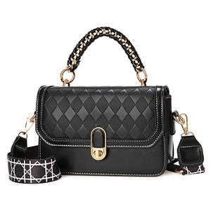 Black quilted crossbody bag with golden twist lock and patterned wide shoulder strap