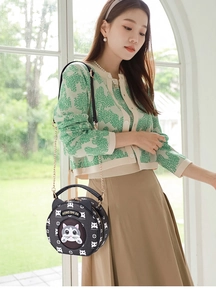 Stylish round crossbody bag featuring cat ear design and cat head monogram on model