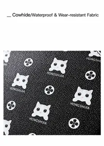 Detail of waterproof pebbled cowhide leather with logo and white cat pattern on black bag