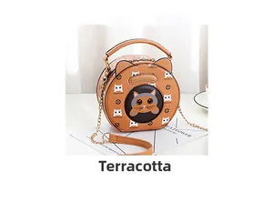 Detail of round crossbody bag with cat ear design and logo pattern in earthy yellow