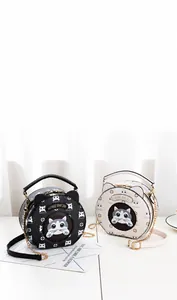 Detail of round cat-ear shoulder bags with floral prints and metal chain straps