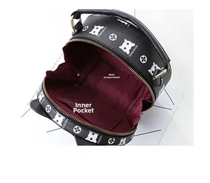 Macro view of round leather crossbody bag showing inner main pocket and burgundy lining