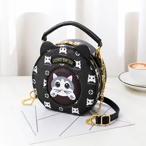 Detail of round black crossbody bag featuring cat ears and elegant gold chain strap