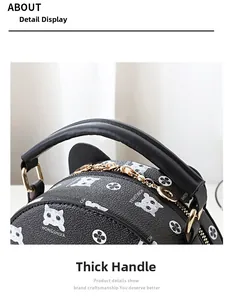 Detail of a round black leather bag with cute cat ears and a sturdy carrying handle