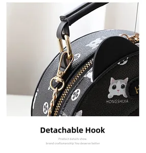 Detail of the detachable gold chain hook and cat ear design on a round leather bag