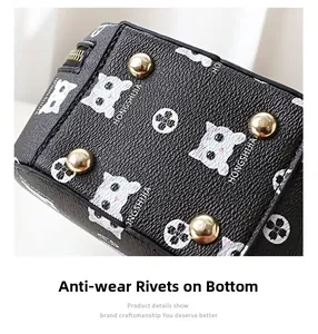Macro detail of black leather bag base featuring four gold protective metal rivets