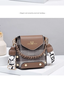 Detail of a brown and grey checkered crossbody bag with gold handle and logo