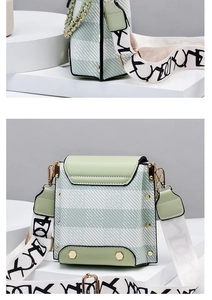 Detail of light green leather and striped fabric crossbody bag with wide logo strap