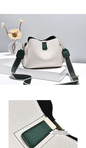 Detail of lychee pattern cream bucket bag with dark green patch and striped wide strap