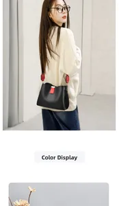 Detail of black textured bucket bag with red contrast straps worn by a female model