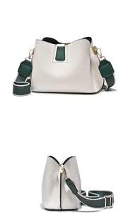 Dual view of white leather bucket bag showing contrast green accents and wide strap