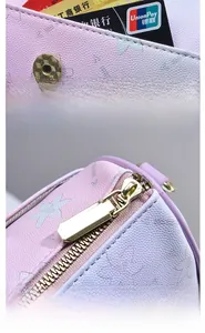 Détail du sac cylindrique violet avec motif abeille, fente pour carte et zip doré