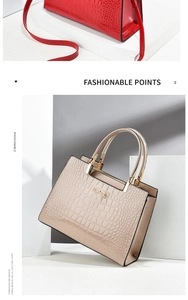 Detail of crocodile textured patent leather handbag with gold metal hardware and handles
