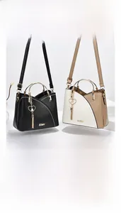 Detail of elegant PU leather handbags with golden handles and tassel heart charms