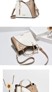 Detail view of contrast color handbag with golden ring handle and heart tassel charm