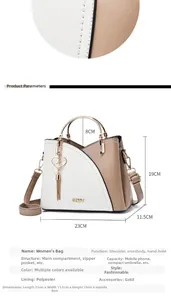 Detail view of khaki and white leather handbag with metal handle and pearl heart charm