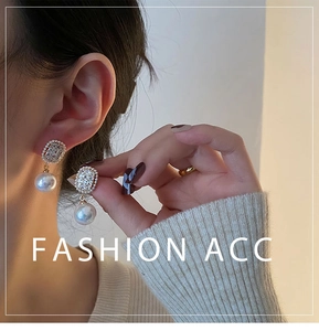 Detail of elegant gold pearl drop earrings with sparkling zircon accents on a model