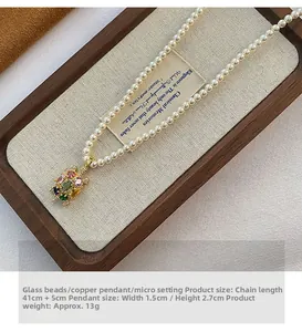 Gros plan d'un collier en perles avec un pendentif tortue coloré sur un plateau en lin