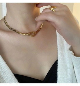 Détail du collier avec pendentif cœur doré sur la clavicule et chaîne plate pour femme