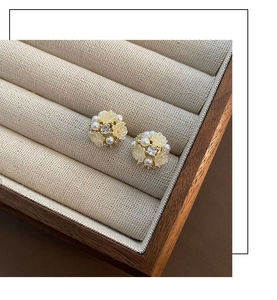 Nahaufnahme eleganter Blumenohrringe mit Perlen und Kristallen in einer Schmuckschatulle
