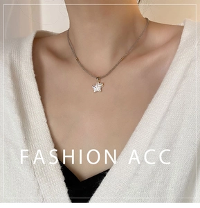 Détail du collier de perles étoile de mer avec pendentif émail blanc sur pull en maille