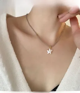 Gros plan du collier pendentif étoile de mer blanche avec perles grises sur le cou d'un modèle