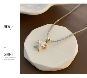 Gros plan sur un pendentif étoile de mer en émail blanc avec perles et collier perlé
