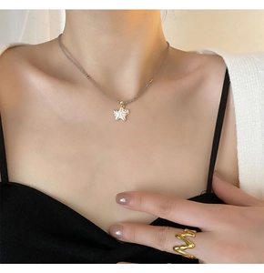 Gros plan détaillé d'un collier pendentif étoile de mer blanche avec une bague en or