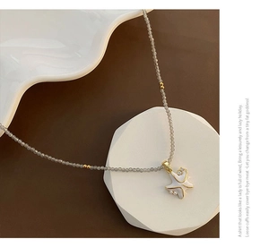 Détail du pendentif étoile de mer en émail blanc avec perles facettées grises