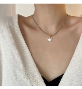 Détail du pendentif étoile de mer blanche sur collier de perles grises sur mannequin
