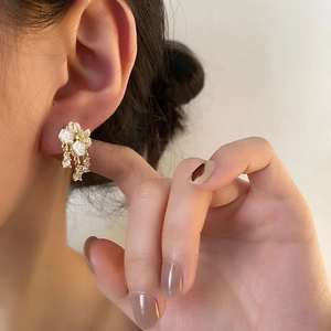 Elegant white camellia flower drop earrings with zircon tassels on a female model